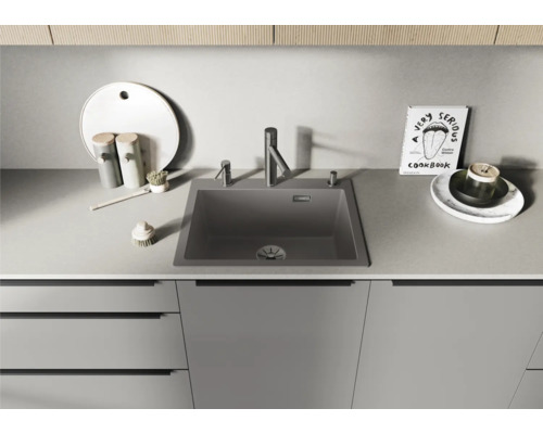 Évier de cuisine avec robinetterie et ustensiles de cuisine sur un plan de travail