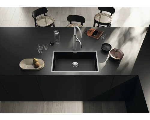 Évier dans un îlot de cuisine moderne avec robinetterie, vaisselle et décoration