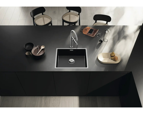 Évier de cuisine avec robinetterie sur un comptoir de cuisine avec vaisselle et décoration