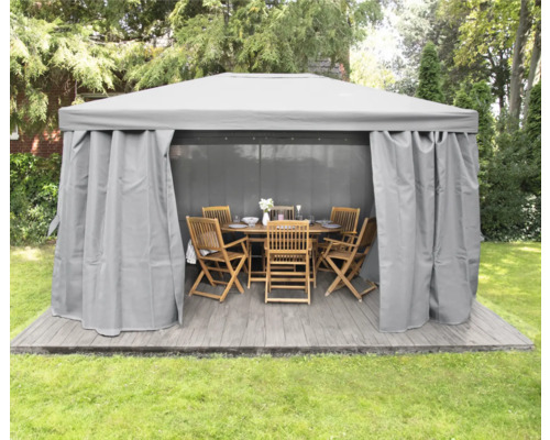 Pavillon avec rideaux et meubles de jardin sur une terrasse dans le jardin