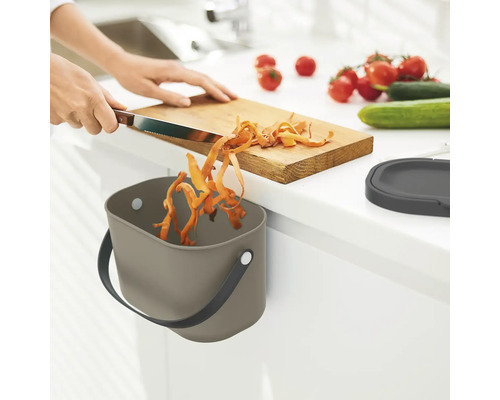 Scène de cuisine avec poubelle pour l''élimination des déchets de cuisine lors de la coupe des légumes