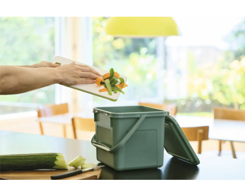 Les déchets de légumes sont jetés dans un seau à compost avec couvercle.