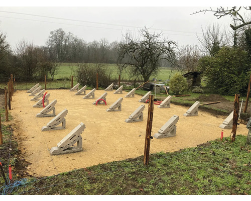 Préparation du chantier avec fondations en béton pour un projet de jardin en extérieur.