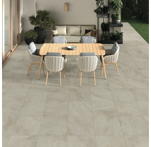 Terrasse avec carrelage de sol, table de jardin et chaises.