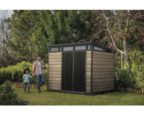 Scène de jardin avec abri de jardin, homme et enfant sur pelouse.