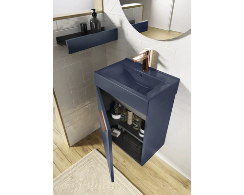 Modernes Badezimmer mit blauem Waschtischunterschrank, offenem Regal und rundem Spiegel