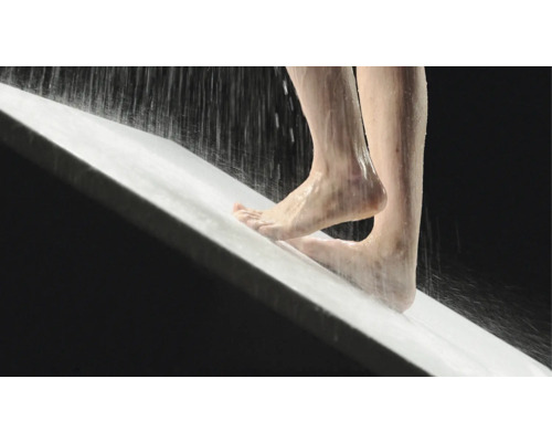 Personne debout sous la douche dans un bac à douche.