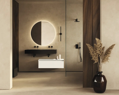 Badezimmer mit runder Spiegelleuchte, schwarzem Waschtisch, weissem Unterschrank und Dusche.