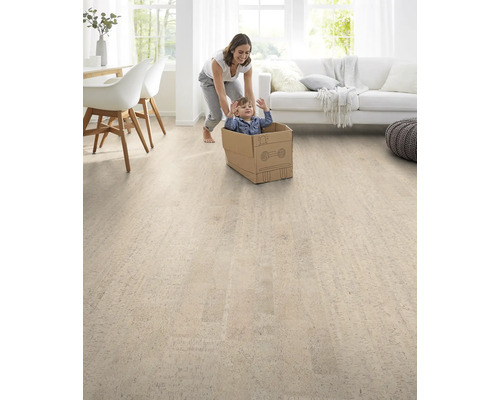 Salon lumineux avec sol en liège, mère poussant un enfant dans un carton