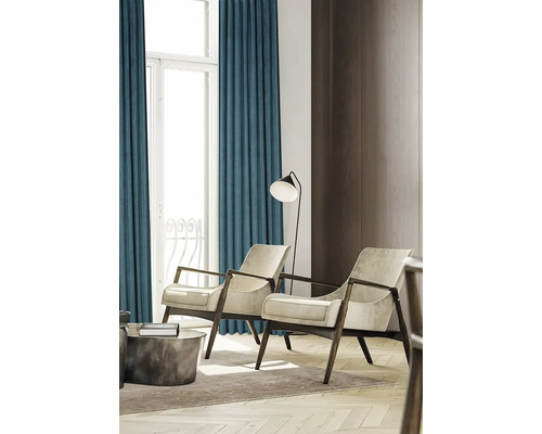 Salon avec rideaux, deux fauteuils et un lampadaire