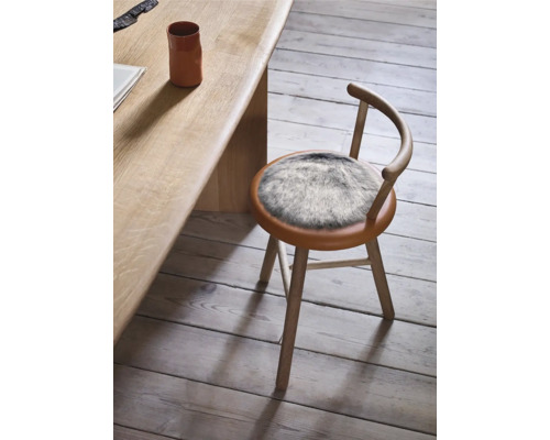 Chaise en bois avec coussin en fausse fourrure près de la table