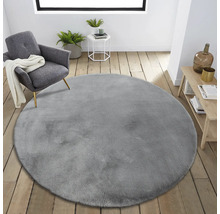 Aménagement intérieur avec tapis rond gris, fauteuil et table d''appoint