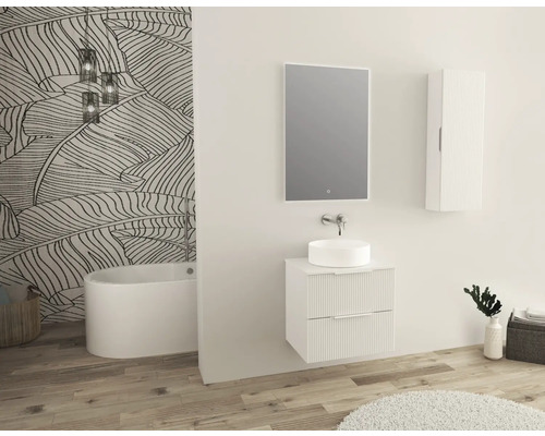 Salle de bains avec meuble-lavabo, miroir et armoire haute devant un mur à motifs de feuilles