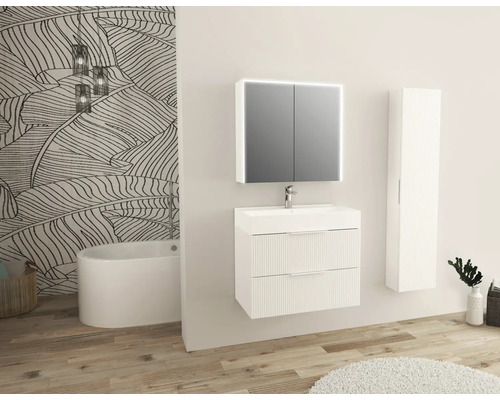 Salle de bains avec lavabo, armoire de toilette, armoire haute et baignoire devant un mur à motifs végétaux