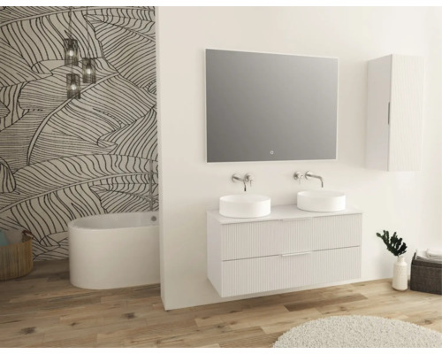 Salle de bains lumineuse avec double vasque, miroir, armoire suspendue, baignoire et papier peint à motifs