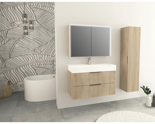 Badezimmer mit Waschtischunterschrank, Spiegelschrank, Hochschrank und Badewanne.