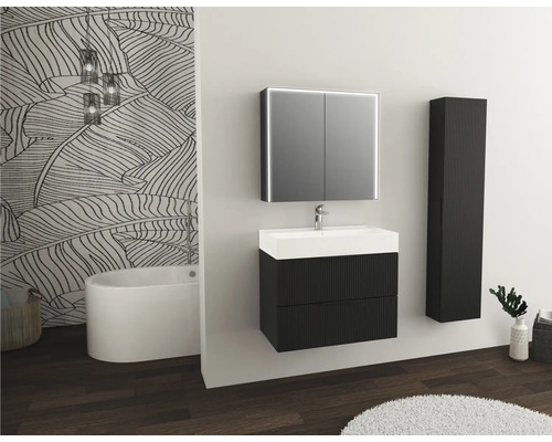 Salle de bains lumineuse avec meuble sous-lavabo, armoire de toilette, armoire haute, baignoire et papier peint à motifs floraux.