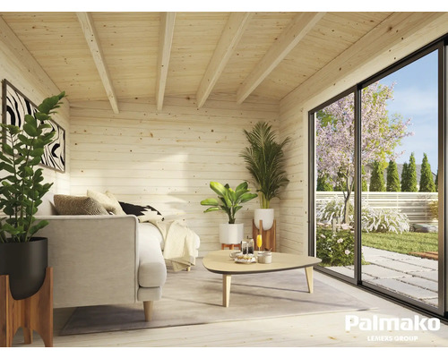Cabane en bois claire avec canapé, table et vue sur le jardin à travers une grande porte coulissante.