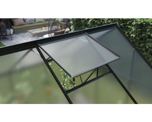 Vue détaillée d''une serre avec une fenêtre ouverte pour la ventilation.