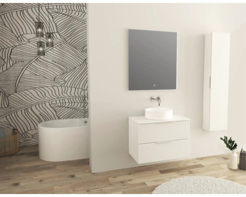 Salle de bains moderne avec lavabo, miroir, armoire suspendue et baignoire îlot devant un mur avec papier peint à motifs de feuilles.