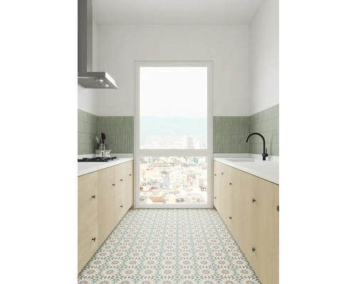 Helle Küche mit Arbeitsplatten, Spüle, Dunstabzugshaube und gemusterten Bodenfliesen.