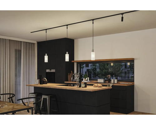 Cuisine moderne avec îlot de cuisine noir, plan de travail en bois et éclairage sur rail avec suspensions