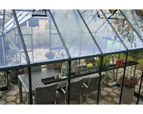 Serre avec table à manger et chaises à l''intérieur.