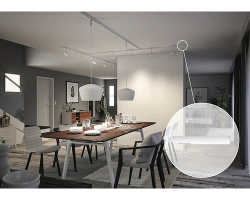 Salle à manger avec table, chaises, suspensions et système de rails électriques au plafond