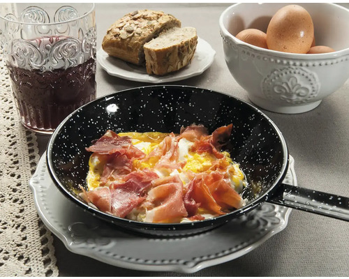Nature morte avec des œufs au plat au jambon dans une poêle, servis avec du pain, des œufs et une boisson