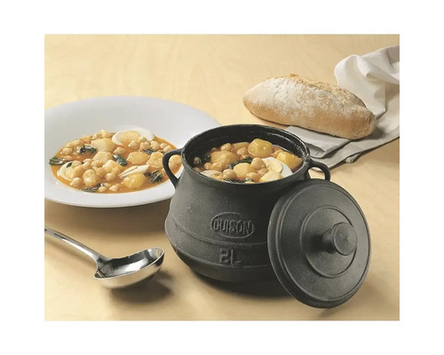 Gusseisentopf mit Deckel und Eintopfgericht, serviert mit Brot und Suppenkelle