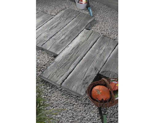 Chemin de jardin avec dalles de passage aspect bois, lit de gravier et potiron dans un panier