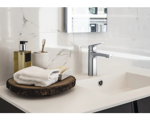 Plan de toilette de salle de bains avec robinet, serviettes et accessoires de bain