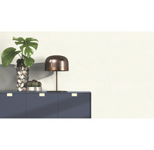 Arrangement décoratif avec table, lampe, vase et plantes sur une armoire.