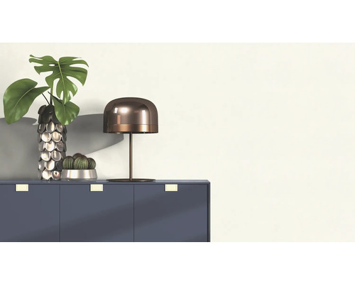 Dekoratives Arrangement mit Tisch, Lampe, Vase und Pflanzen auf einem Schrank.