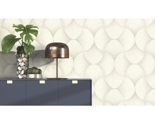 Papier peint décoratif avec motif circulaire derrière une commode avec lampe et plantes