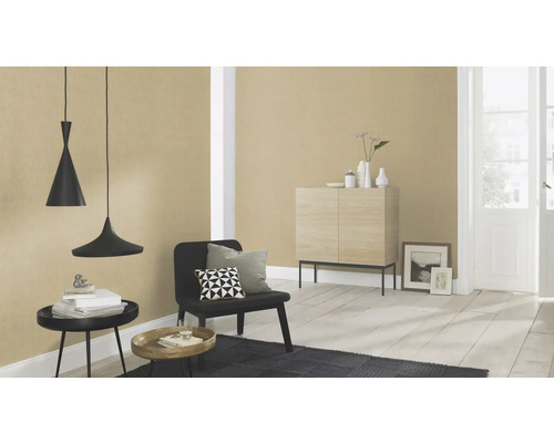 Salon avec suspensions, chaise, tapis et commode devant un mur tapissé