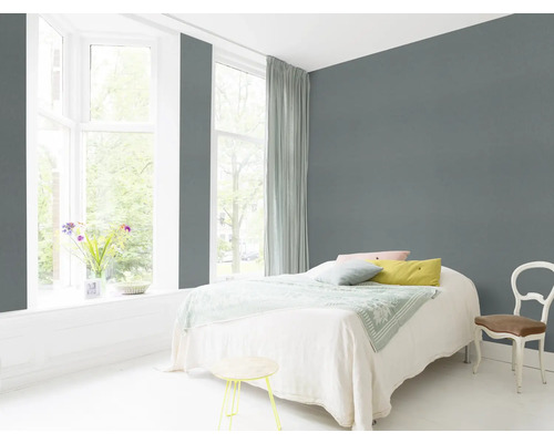 Helles Schlafzimmer mit Bett, Stuhl und grauer Wand