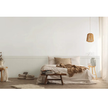 Schlafzimmer mit Bett, Nachttisch, Lampe und Dekorationen in hellem Design.