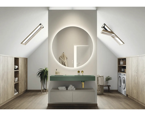 Salle de bains moderne dans les combles avec miroir rond, lavabo, lave-linge et armoires en bois