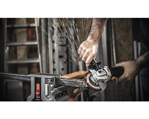 Eine Person benutzt einen Winkelschleifer, um ein Metallstück zu bearbeiten, wobei Funken entstehen.