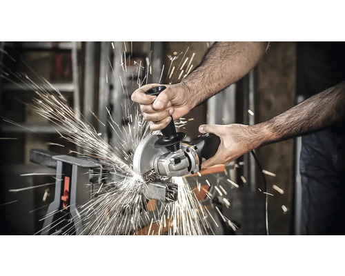Anwender beim Schneiden von Metall mit einem Winkelschleifer, wobei Funken entstehen.