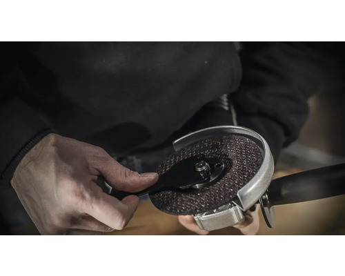 Eine Winkelschleifmaschine wird mit einem Schlüssel bedient.