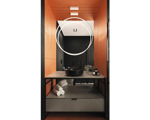 Salle de bains moderne avec lavabo noir, serviettes et lampe circulaire