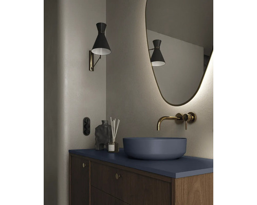 Modernes Badezimmer mit Aufsatzwaschbecken, Wandarmatur, beleuchtetem Spiegel und Wandleuchte.