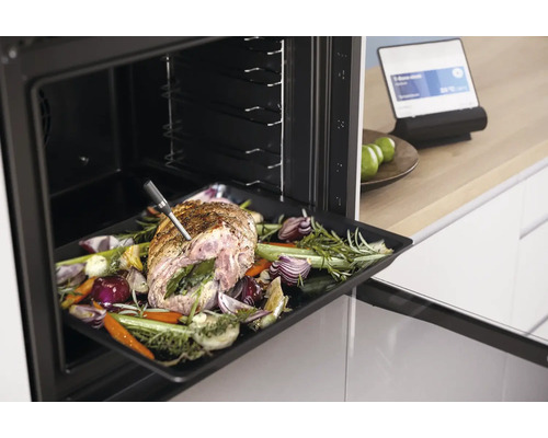 Rôti avec légumes et thermomètre à viande dans le four