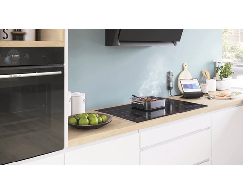 Cuisine claire avec plaque électrique, hotte aspirante et four Bosch.