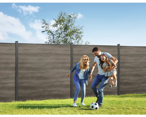 Une famille joue au football dans le jardin avec un écran d''intimité