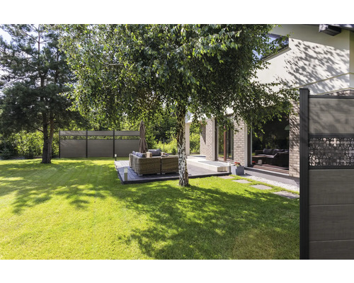 Jardin avec pelouse, clôture en bois et coin salon sur une terrasse