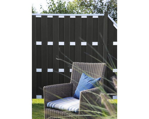 Garten mit Sichtschutzzaun und Korbsessel mit Kissen