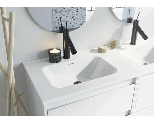 Modernes Badezimmer Waschbecken mit Armatur, Spiegel und Dekoration.